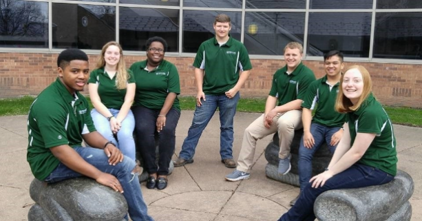 Student Ambassadors posing in matching green polos outside of D-wing